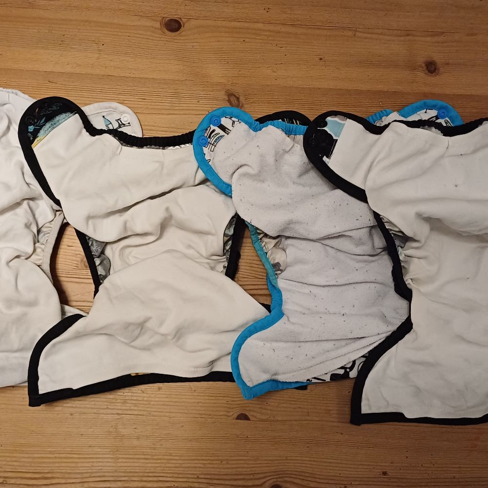 6 Überhosen und 4 Pocket Windeln von Thirsties, diverse Einlagen und eine Wickelunterlage von petit lulu