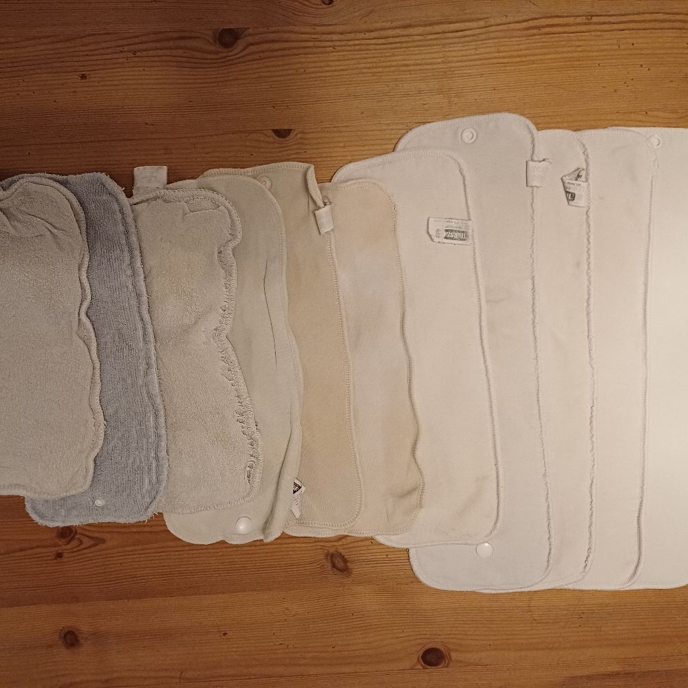 6 Überhosen und 4 Pocket Windeln von Thirsties, diverse Einlagen und eine Wickelunterlage von petit lulu