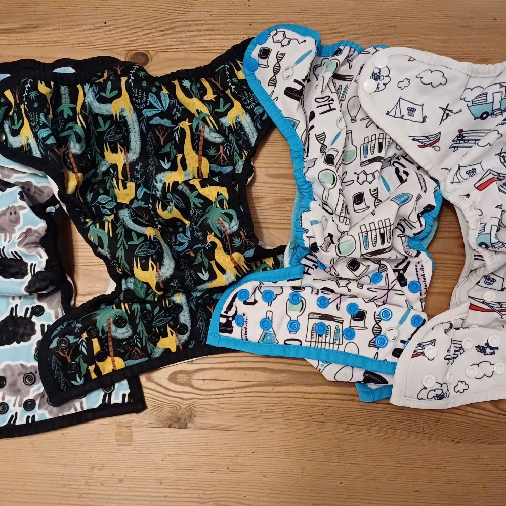 6 Überhosen und 4 Pocket Windeln von Thirsties, diverse Einlagen und eine Wickelunterlage von petit lulu