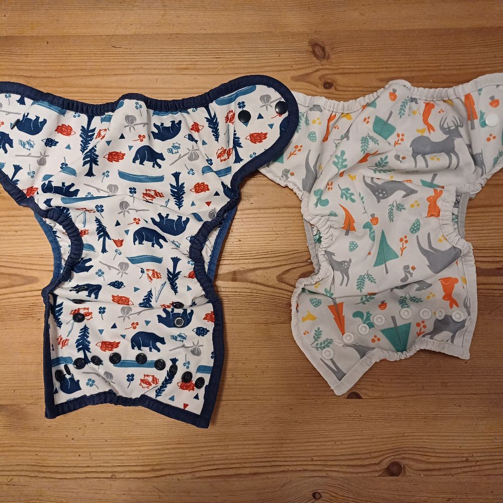 6 Überhosen und 4 Pocket Windeln von Thirsties, diverse Einlagen und eine Wickelunterlage von petit lulu