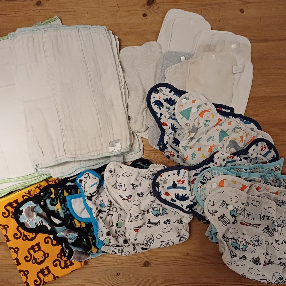 6 Überhosen und 4 Pocket Windeln von Thirsties, diverse Einlagen und eine Wickelunterlage von petit lulu
